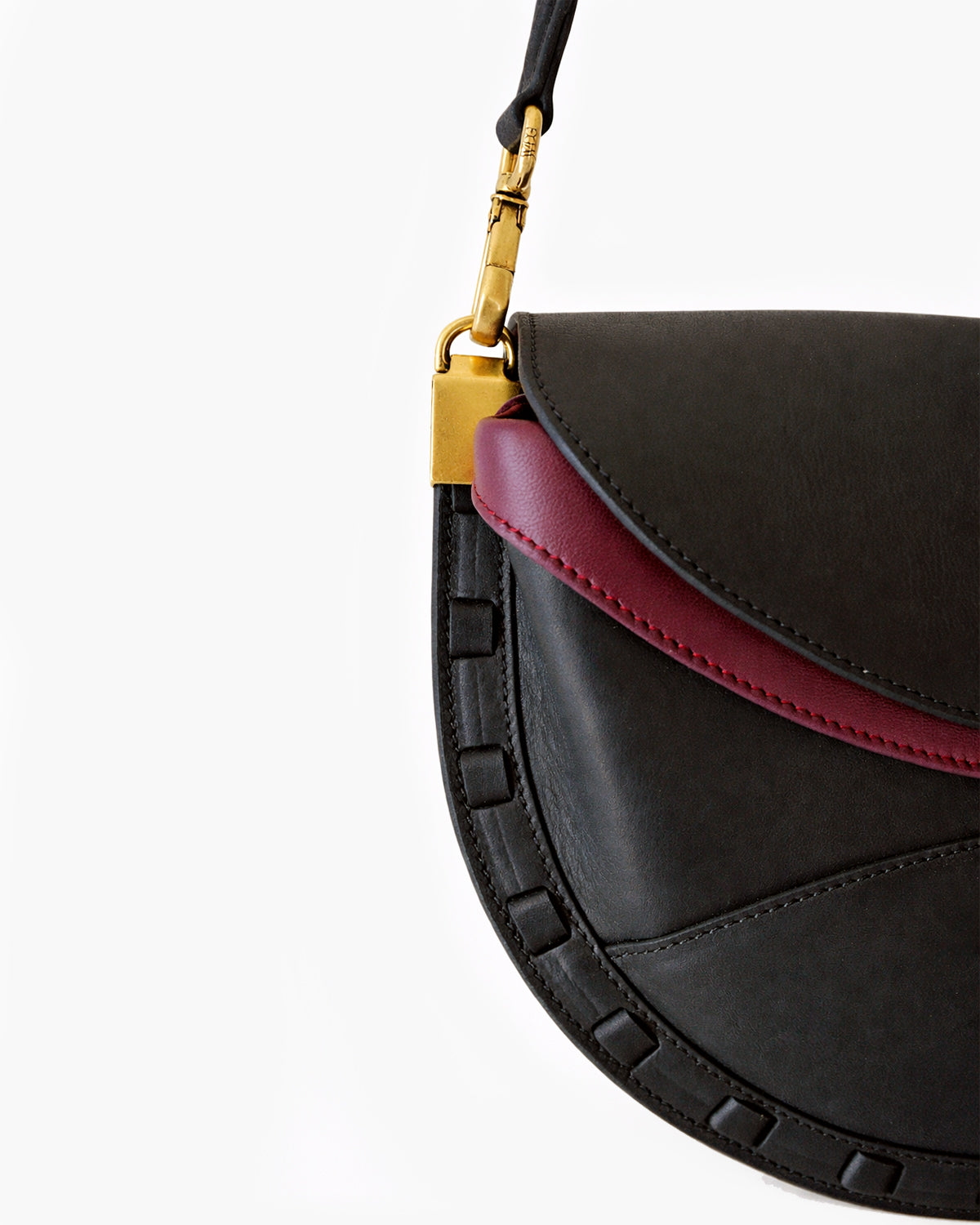 Black and red handbag with gold clasp on a white background