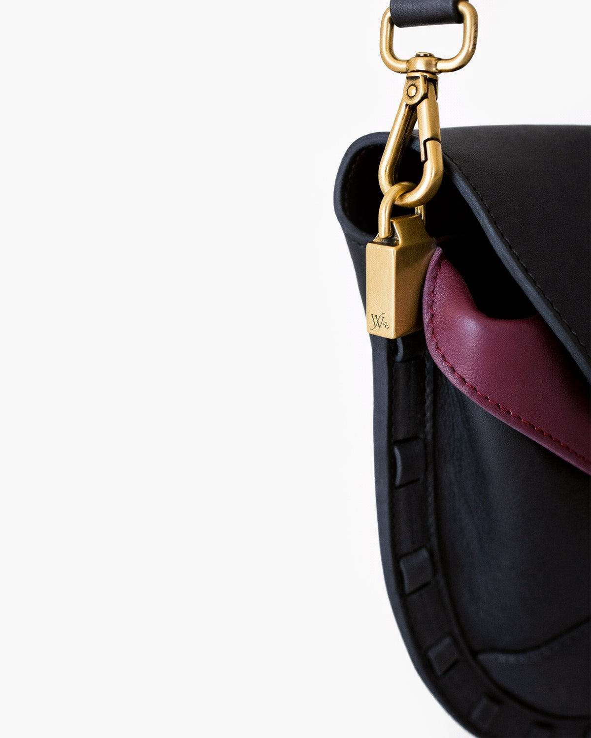 Close-up of a black and purple handbag with a gold handle on a white background