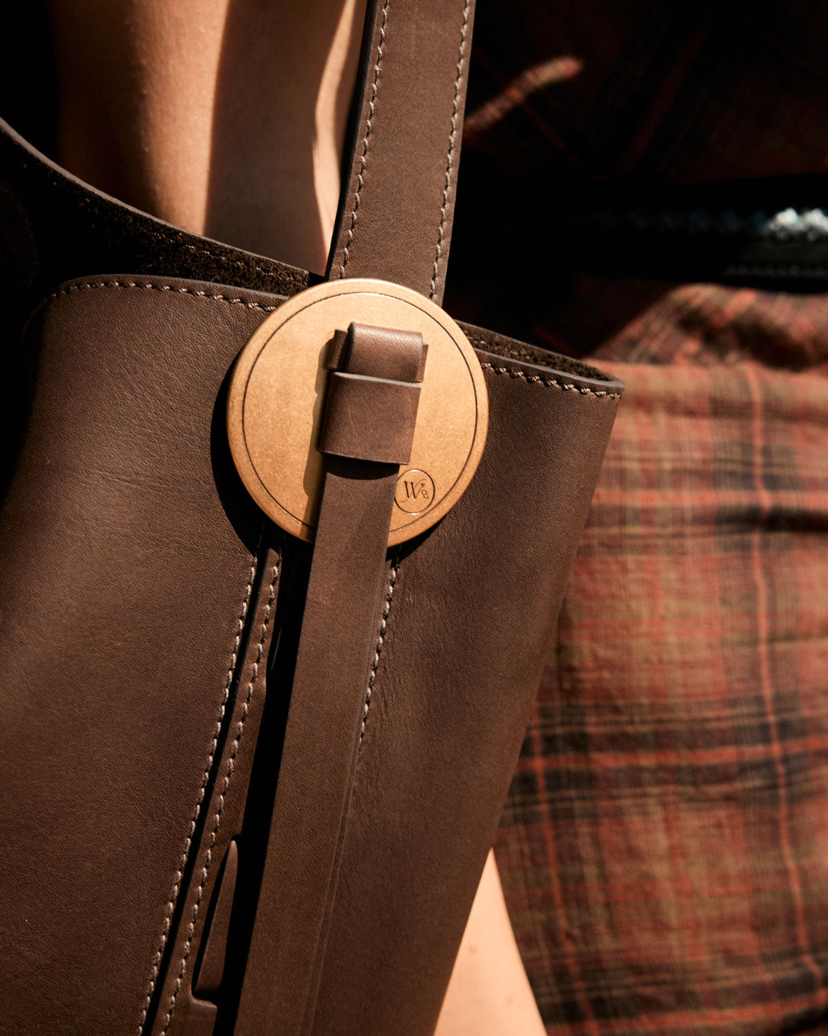 Close-up of a brown leather bag with a visible brand logo.