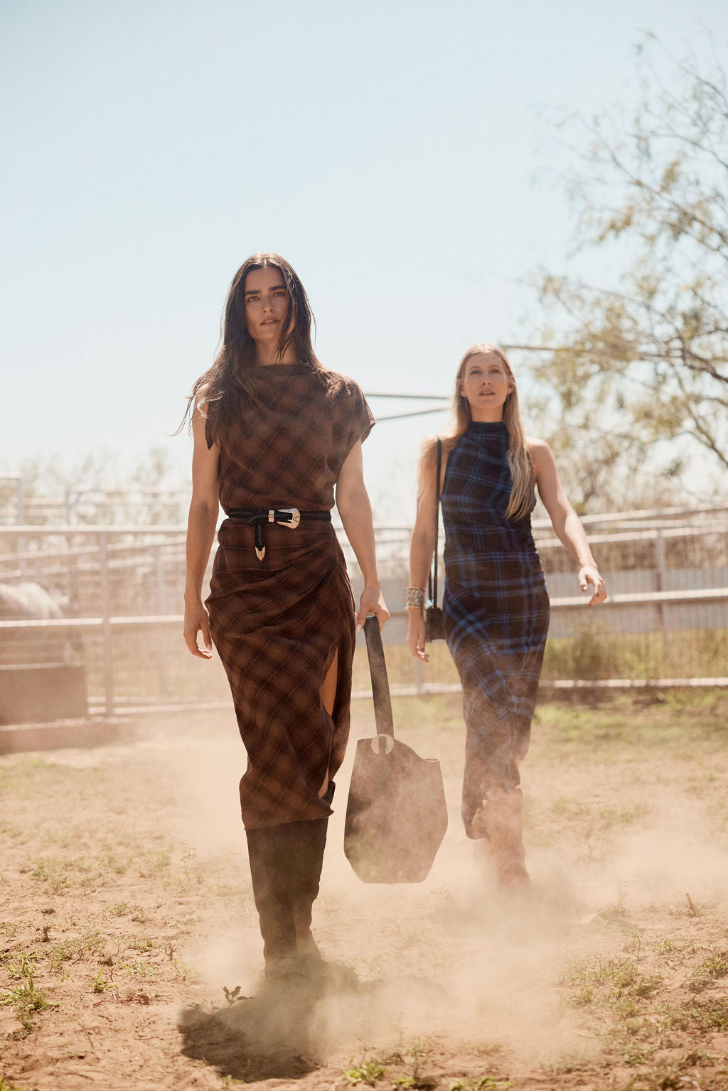 Two women walking on in a paddock with a clear sky