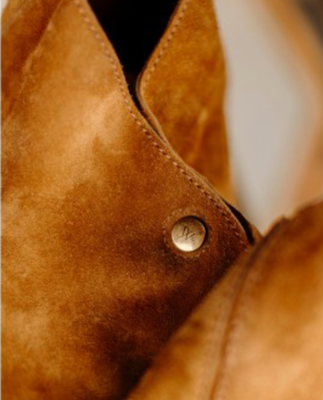 Close-up of a brown leather product with a visible brand logo.