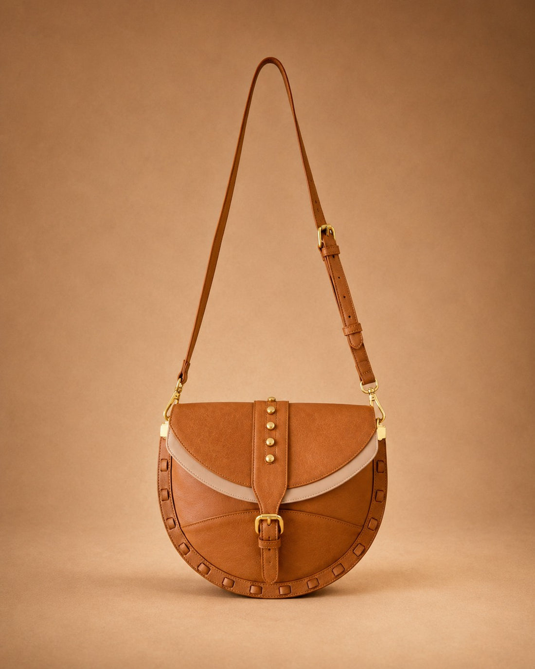 Brown leather handbag with a strap on a beige background