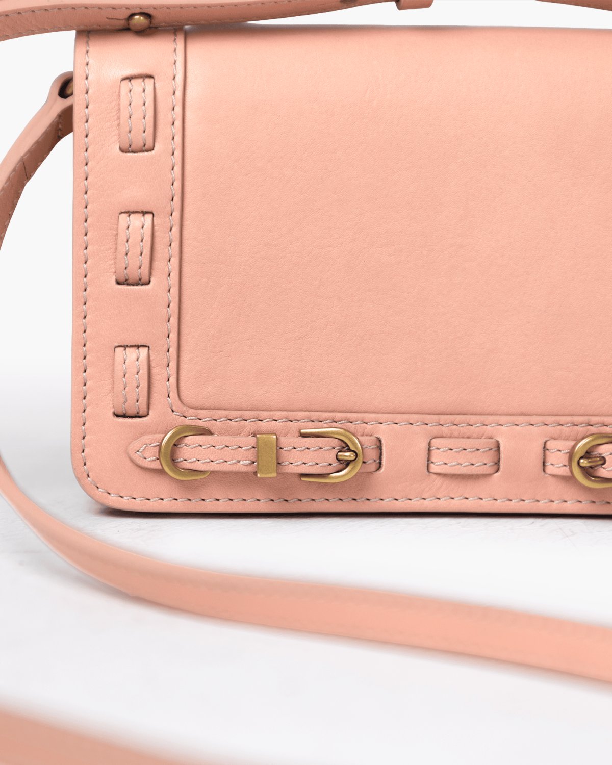 Pink handbag with brass accents on a white background