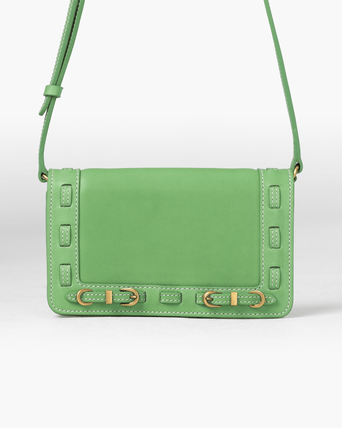 Green handbag with decorative straps on a white background