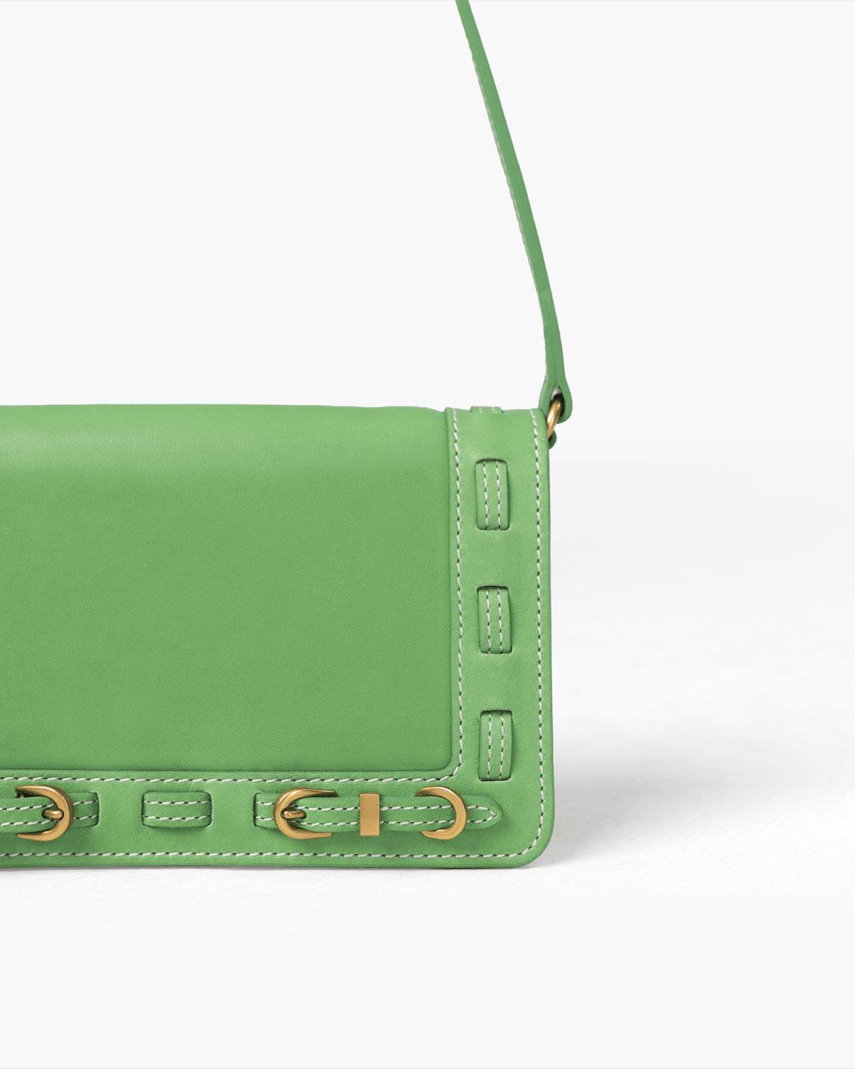 Green handbag with brass hardware on a white background