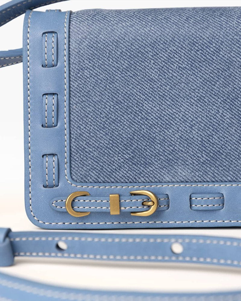 Close up of Denim blue handbag with brass hardware
