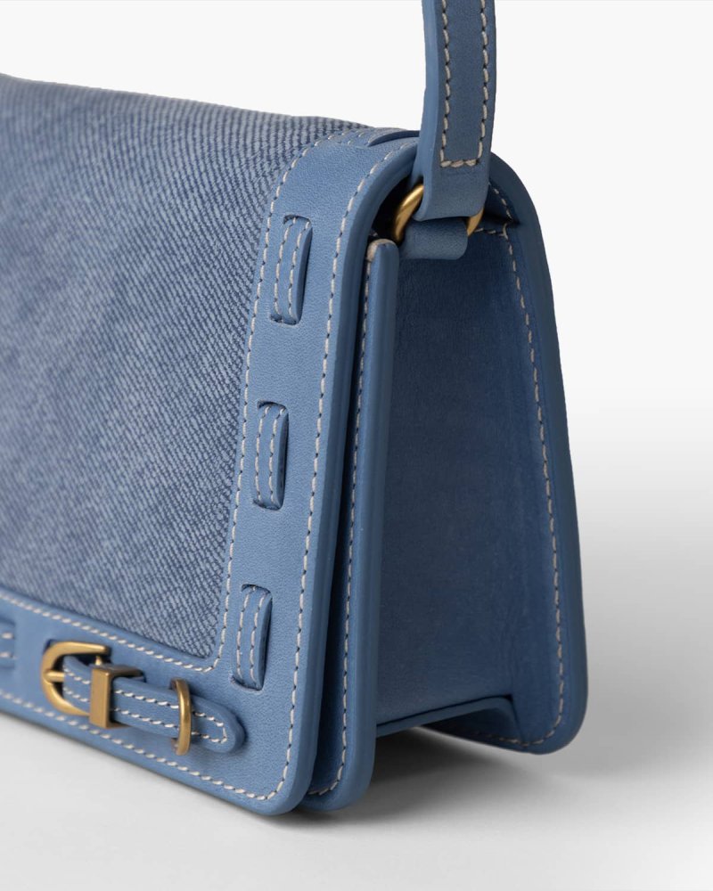 Close up of Denim blue handbag with brass hardware
