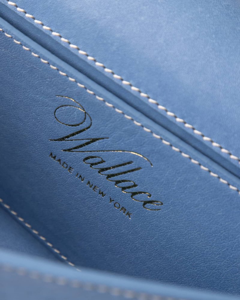 Close-up of a blue leather product with 'Wallace' branding and 'Made in New York' text.
