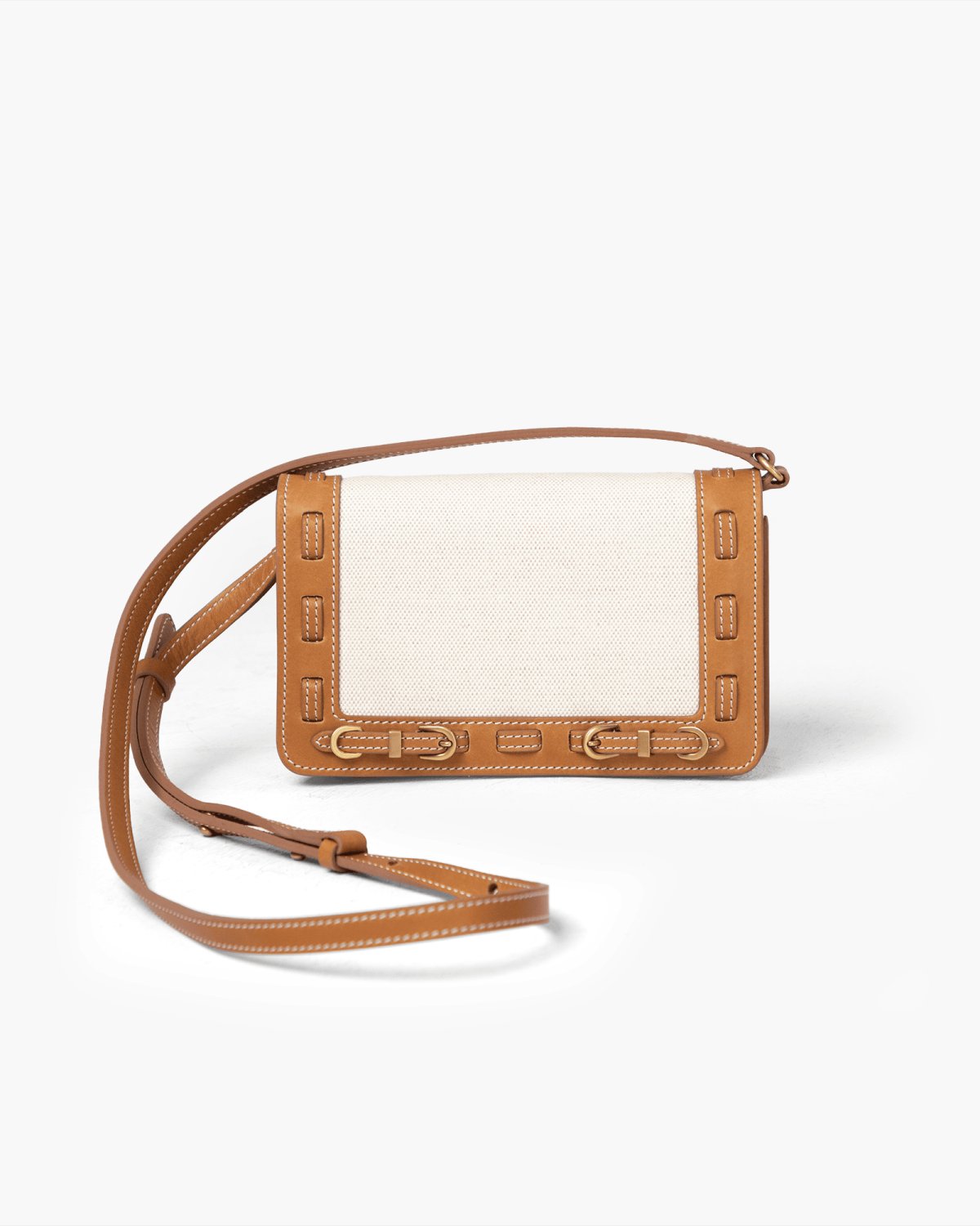 Brown leather handbag with a light linen panel on a light gray background