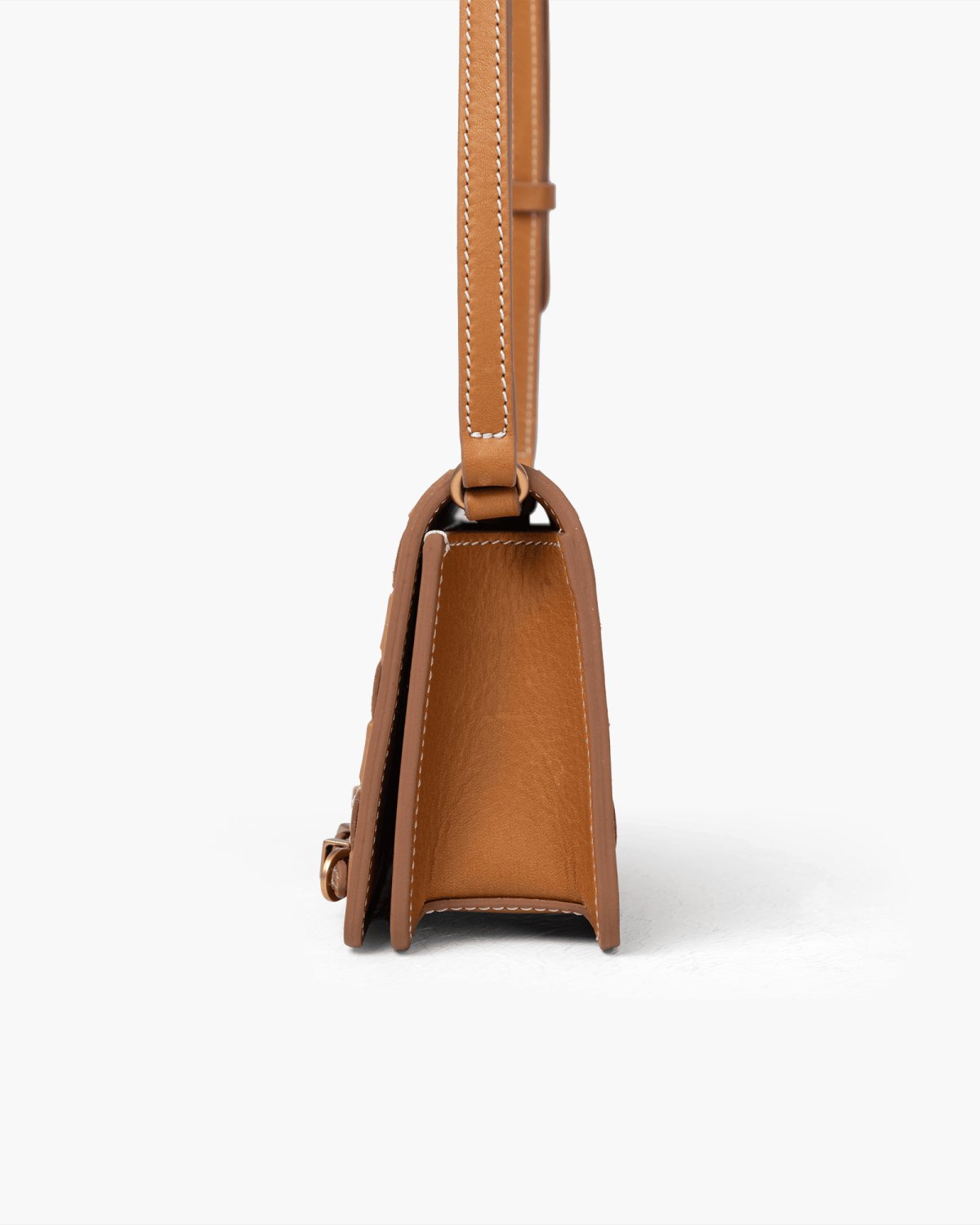 Brown leather handbag with a strap on a white background