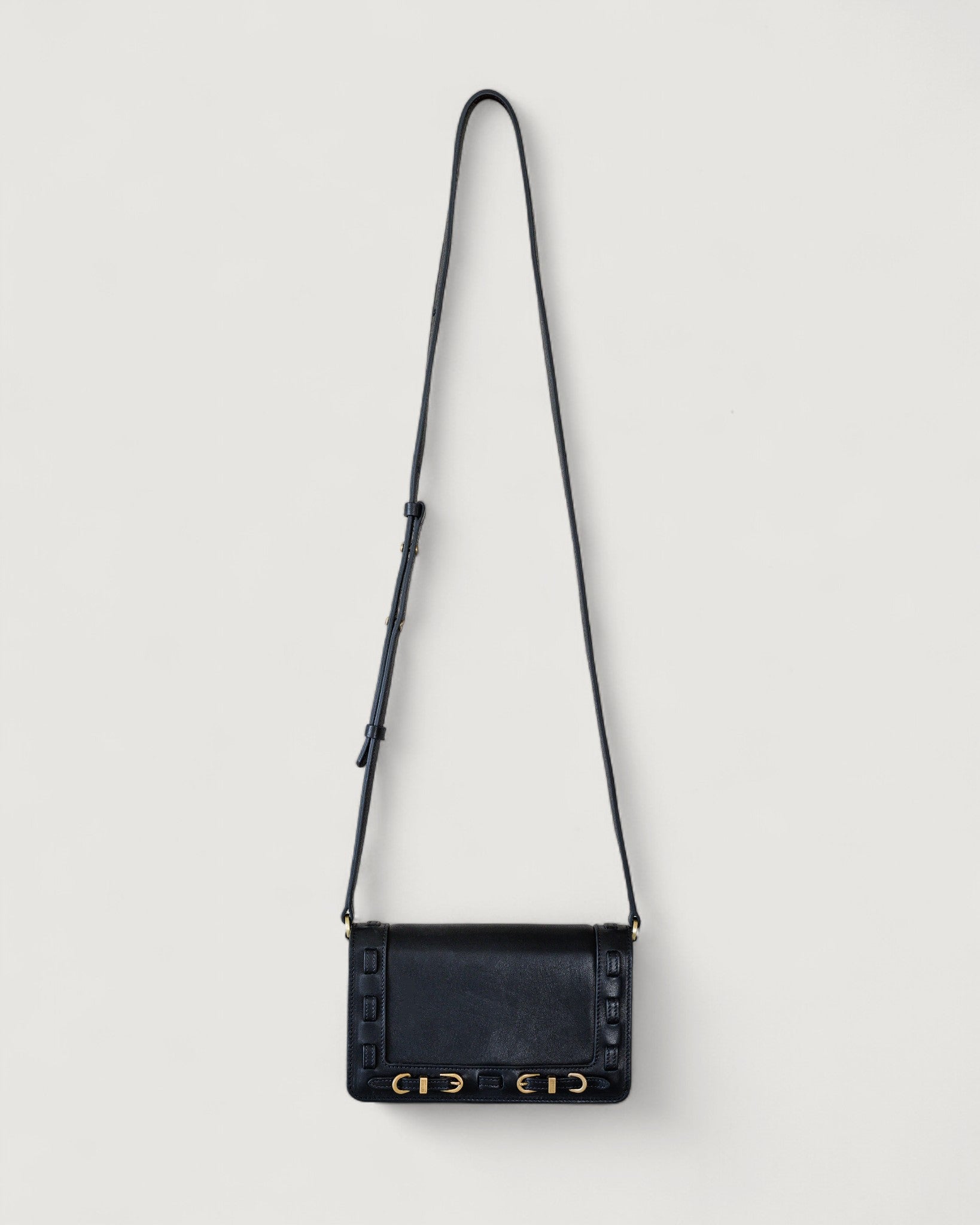 Black handbag with gold accents on a light gray background