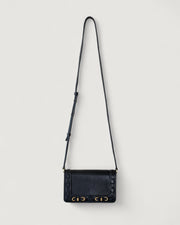 Black handbag with gold accents on a light gray background