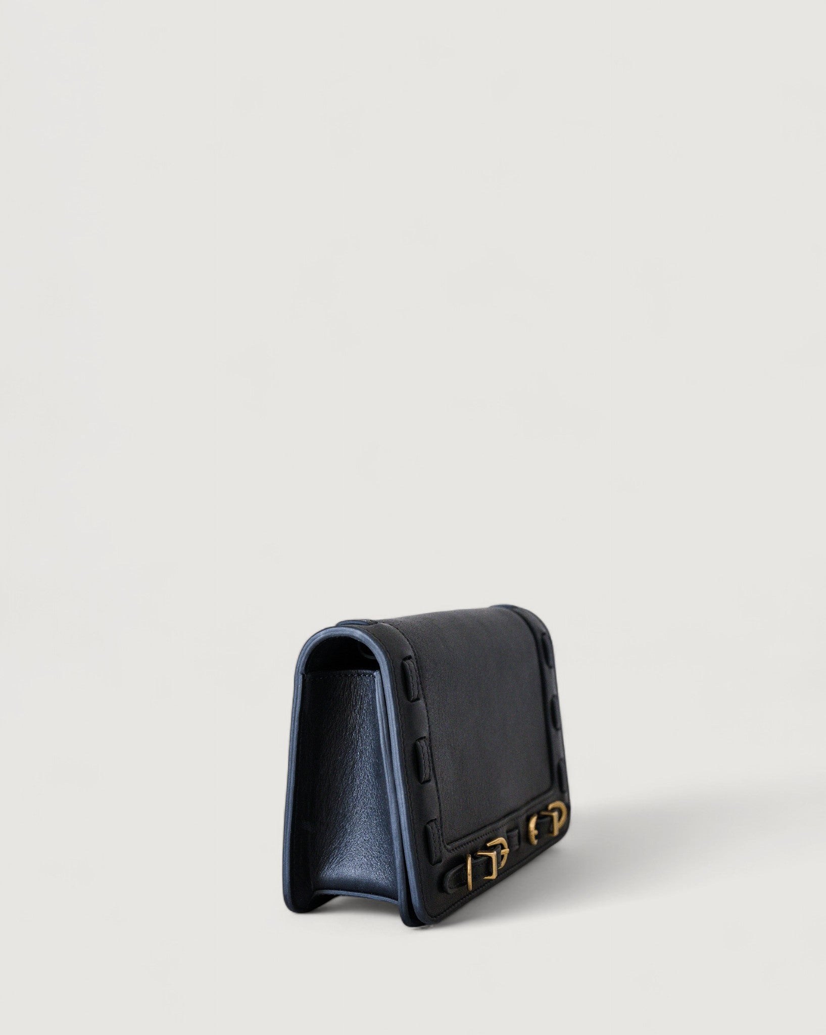 Black leather wallet with brass accents on a light gray background