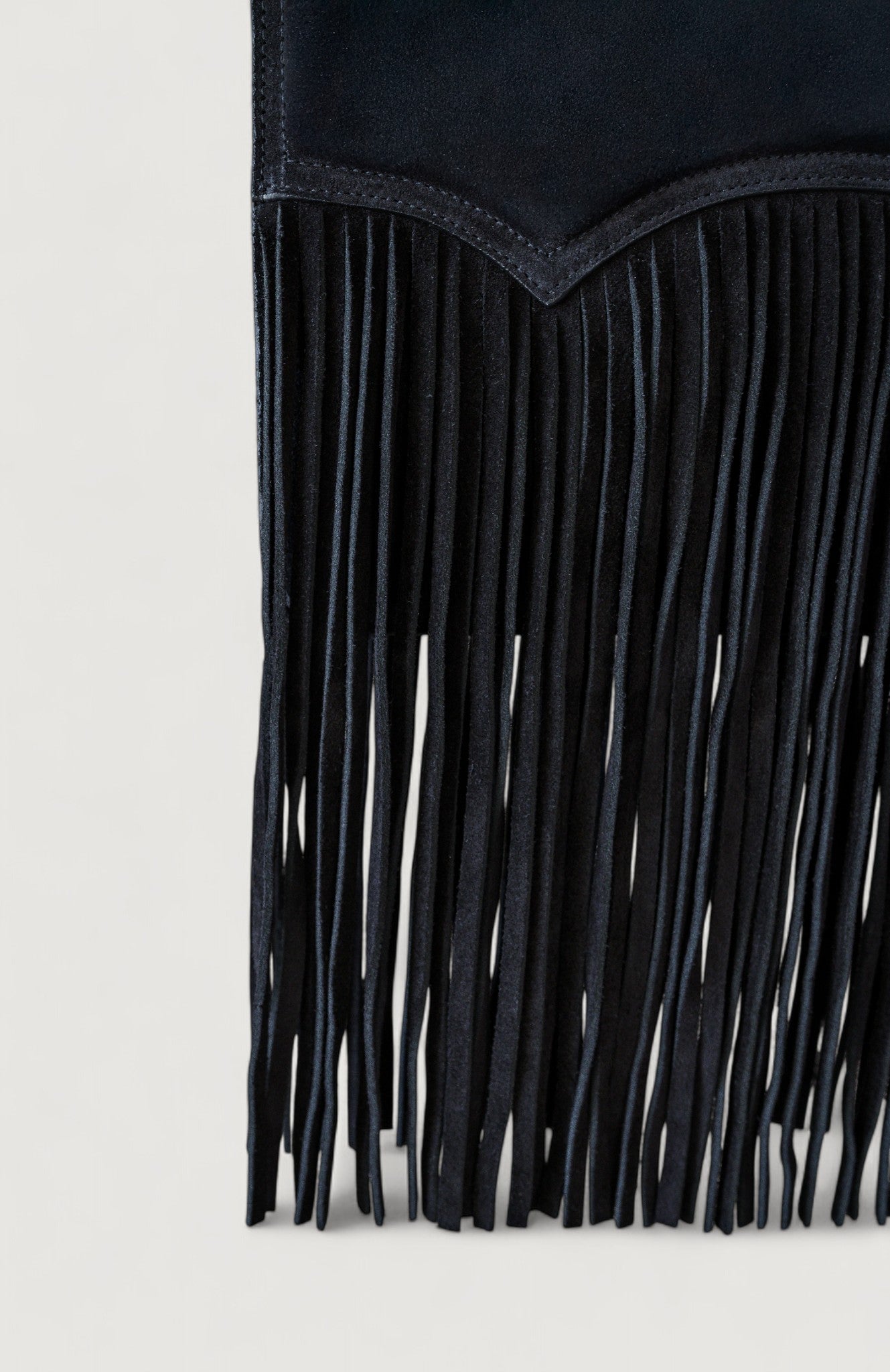 Black fringe handbag on a light gray background
