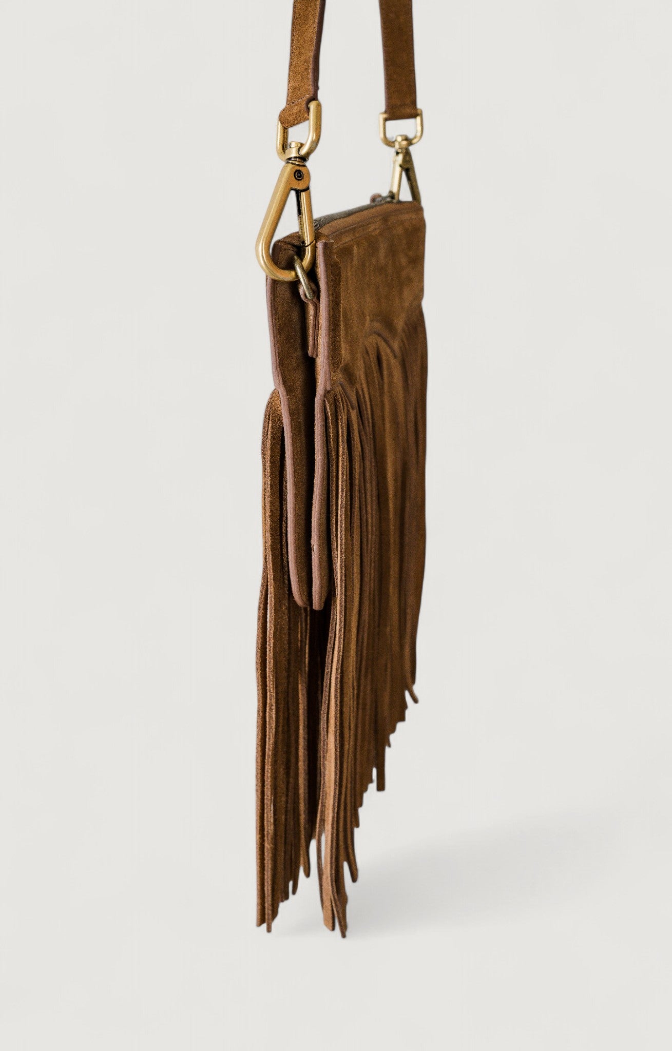 Brown leather fringe bag on a light gray background