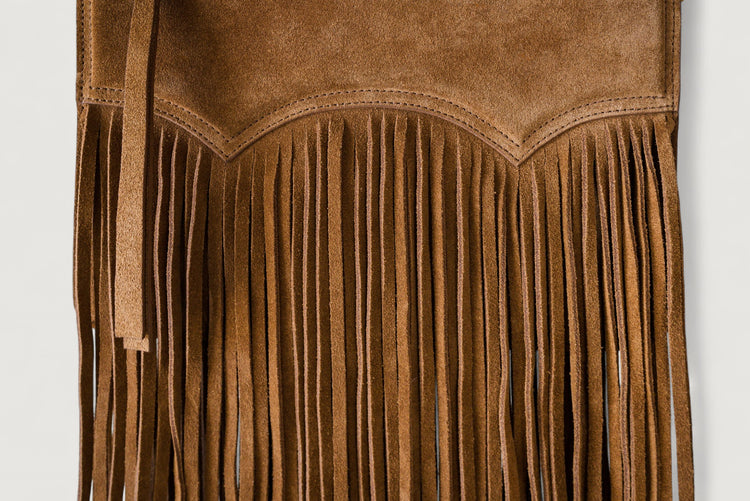 Brown suede bag with fringe on a light gray background