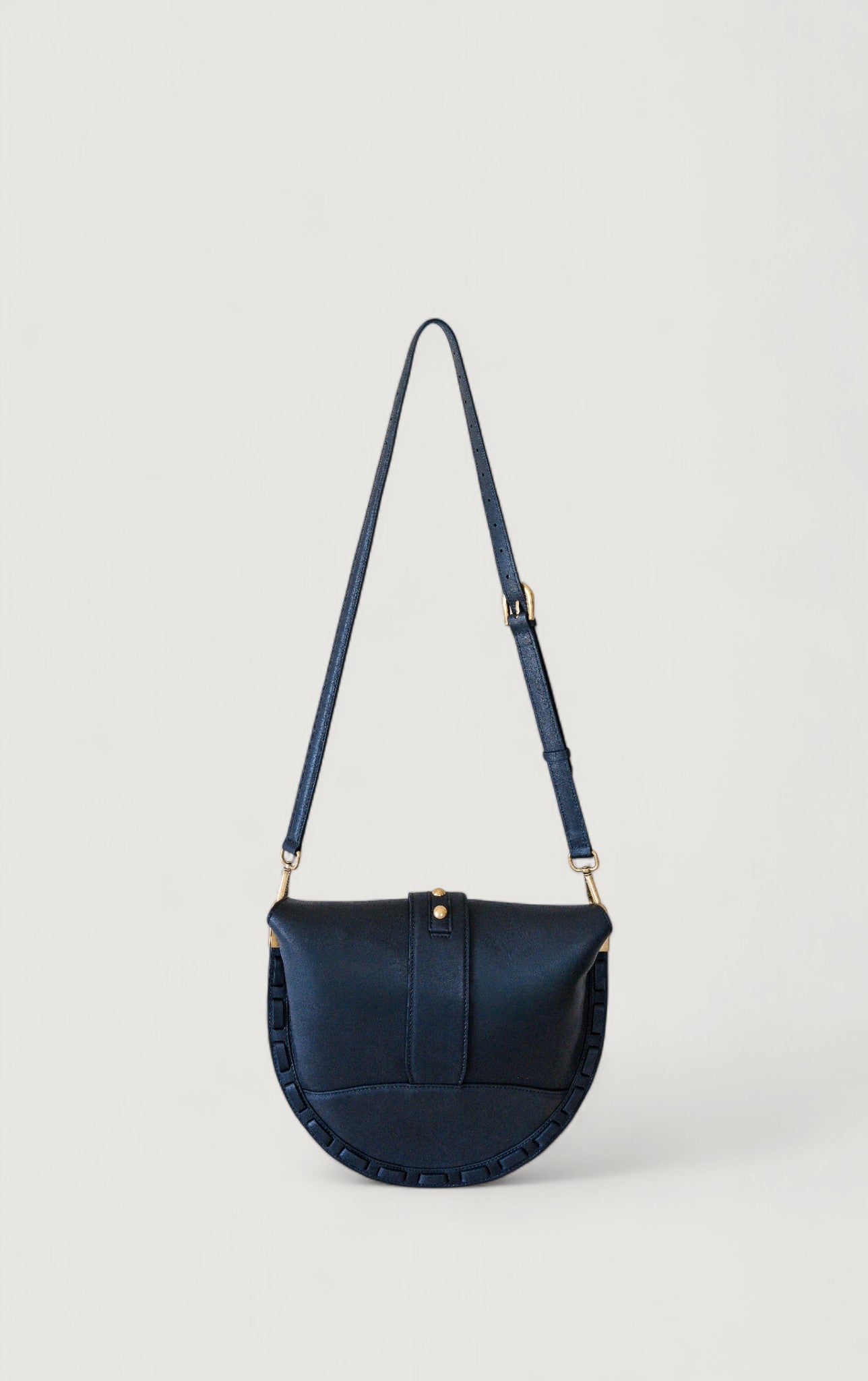 Black handbag with a strap on a light gray background