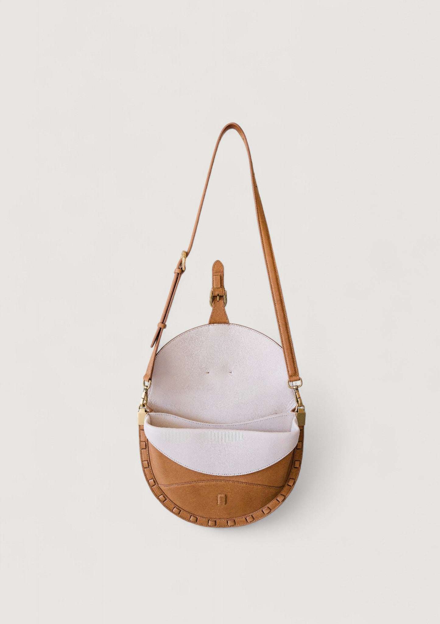 Brown leather handbag with a white interior on a light gray background