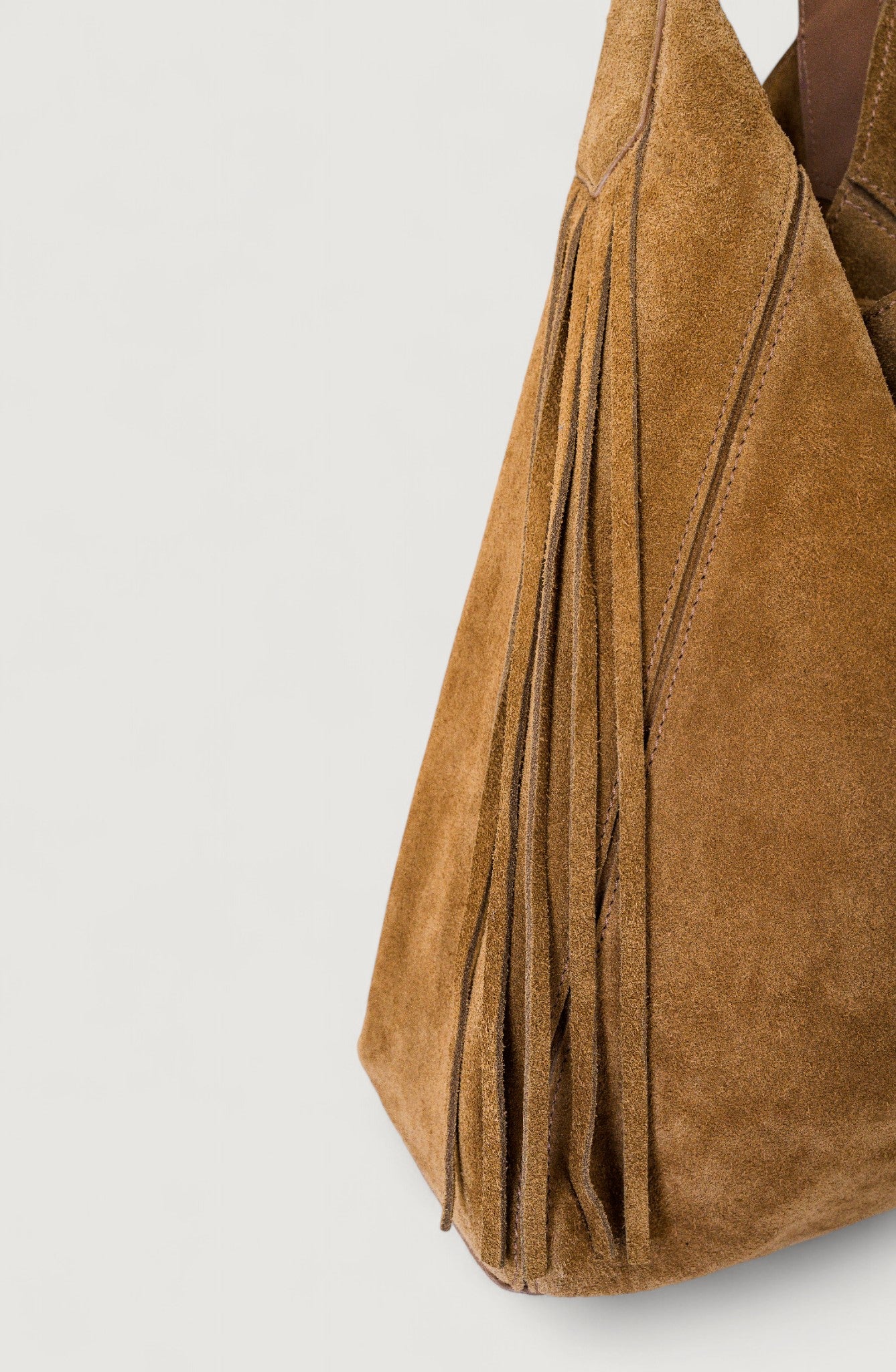 Brown suede handbag on a light gray background
