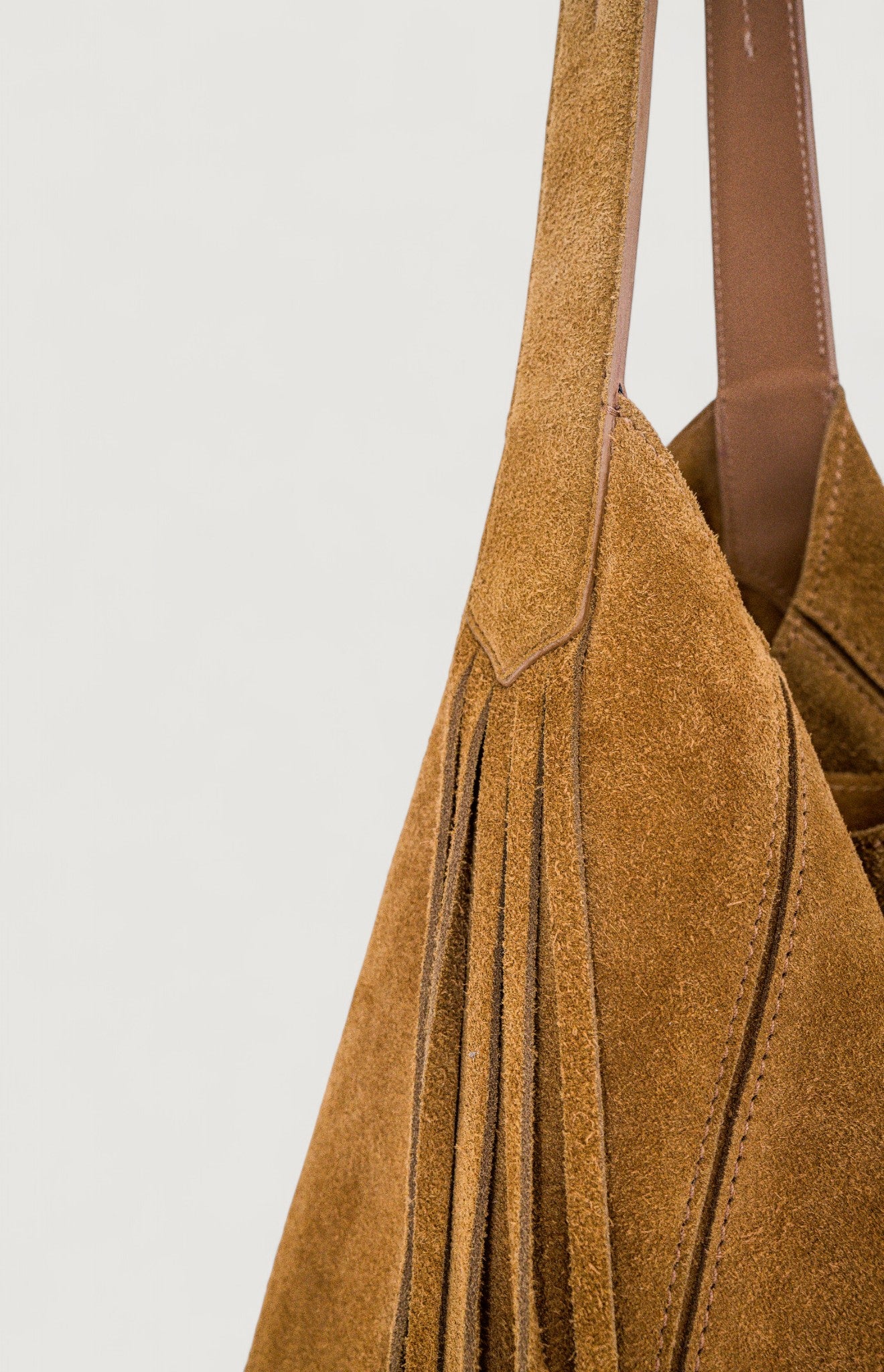 Brown suede handbag with a plain background