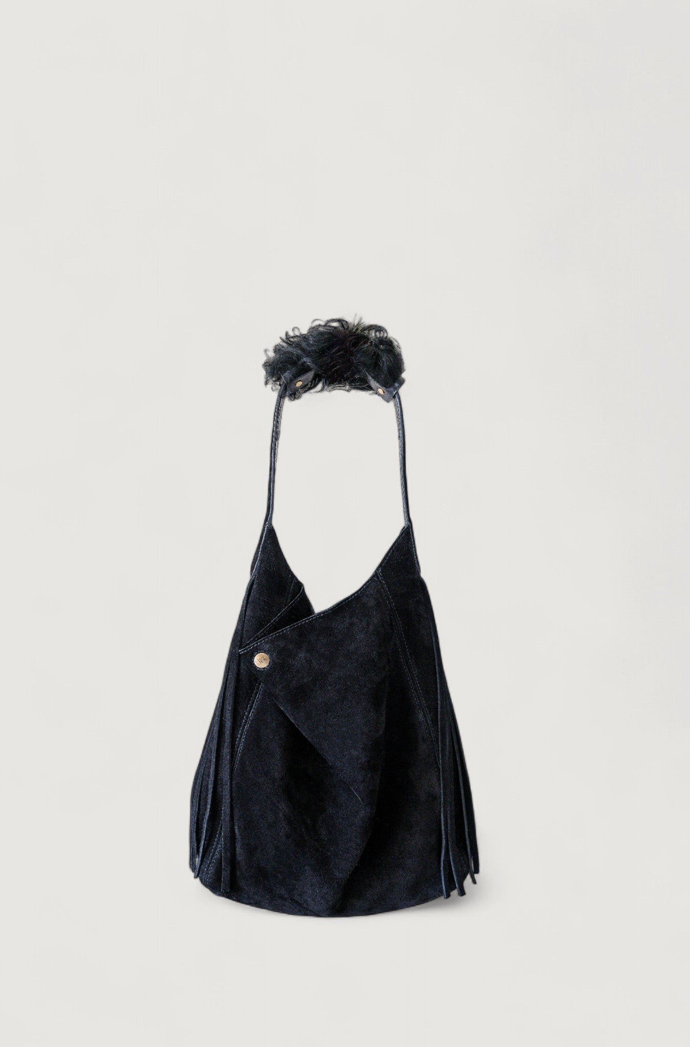 Black handbag with a shearling accessory on a light gray background