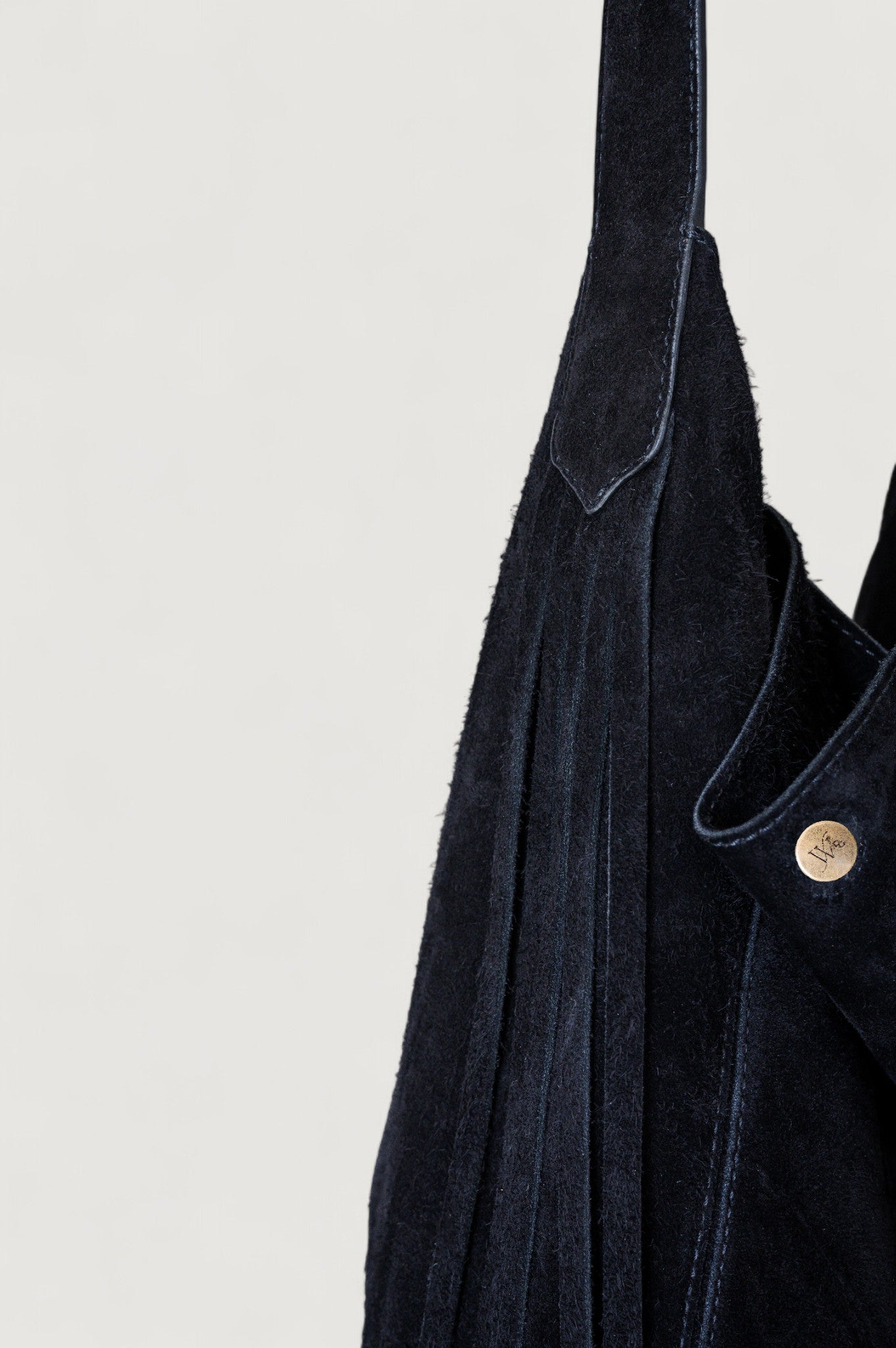 Dark blue denim jacket with brass button details on a light gray background