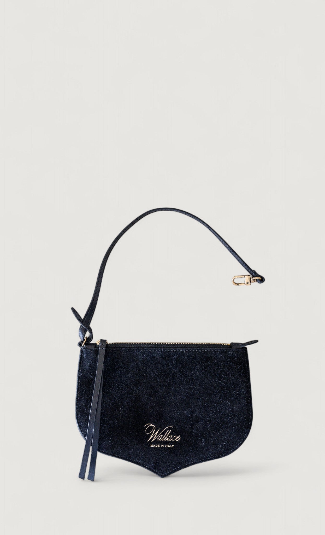 Black handbag with a strap on a light gray background