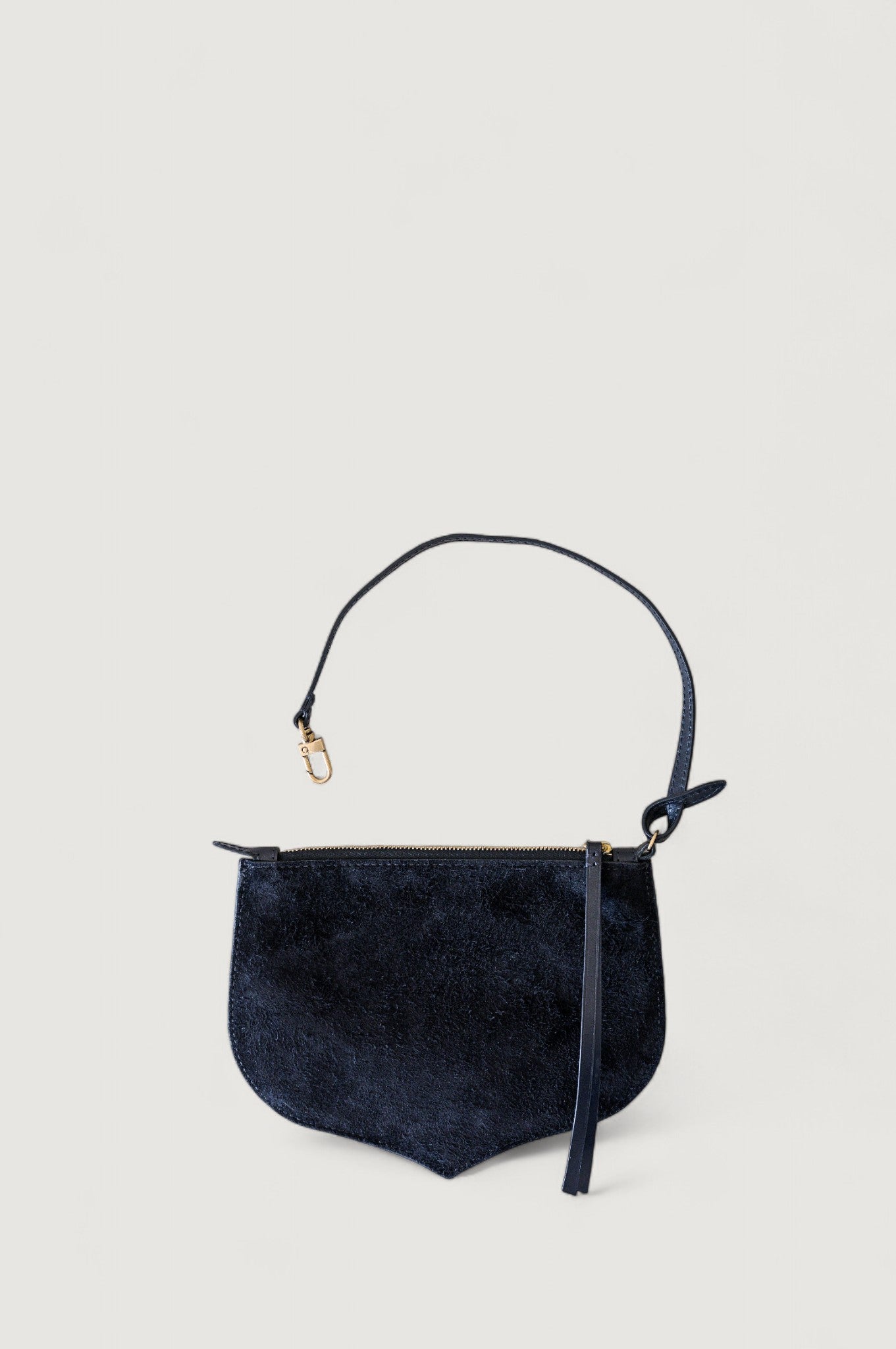 Black handbag with a strap on a light gray background