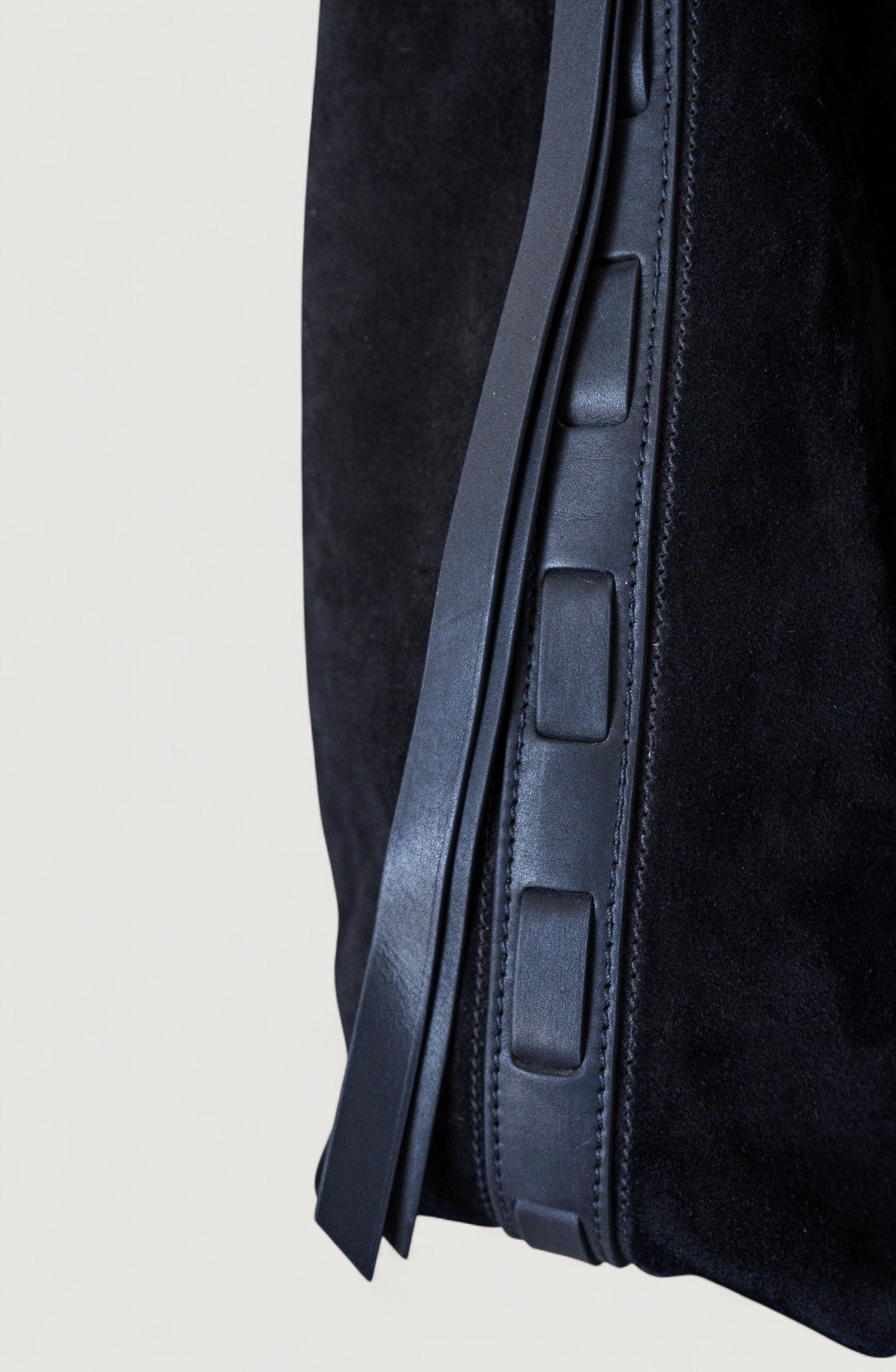 Close-up of a black leather tote on a light gray background