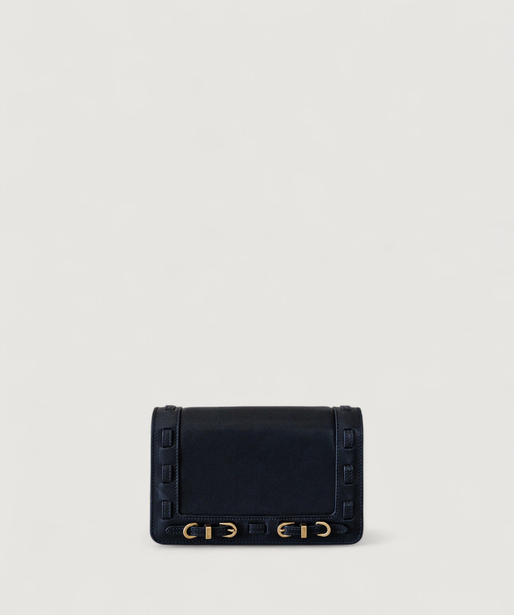 Black handbag with brass accents on a light gray background