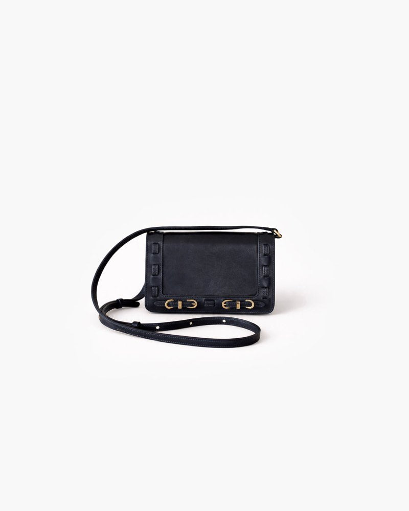 Black handbag with brass hardware on a white background