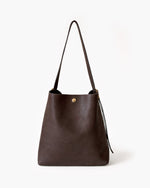 Brown leather handbag with a strap on a white background