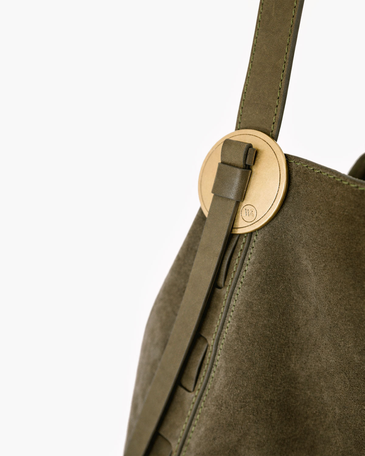 Close-up of a green handbag with a gold clasp on a white background