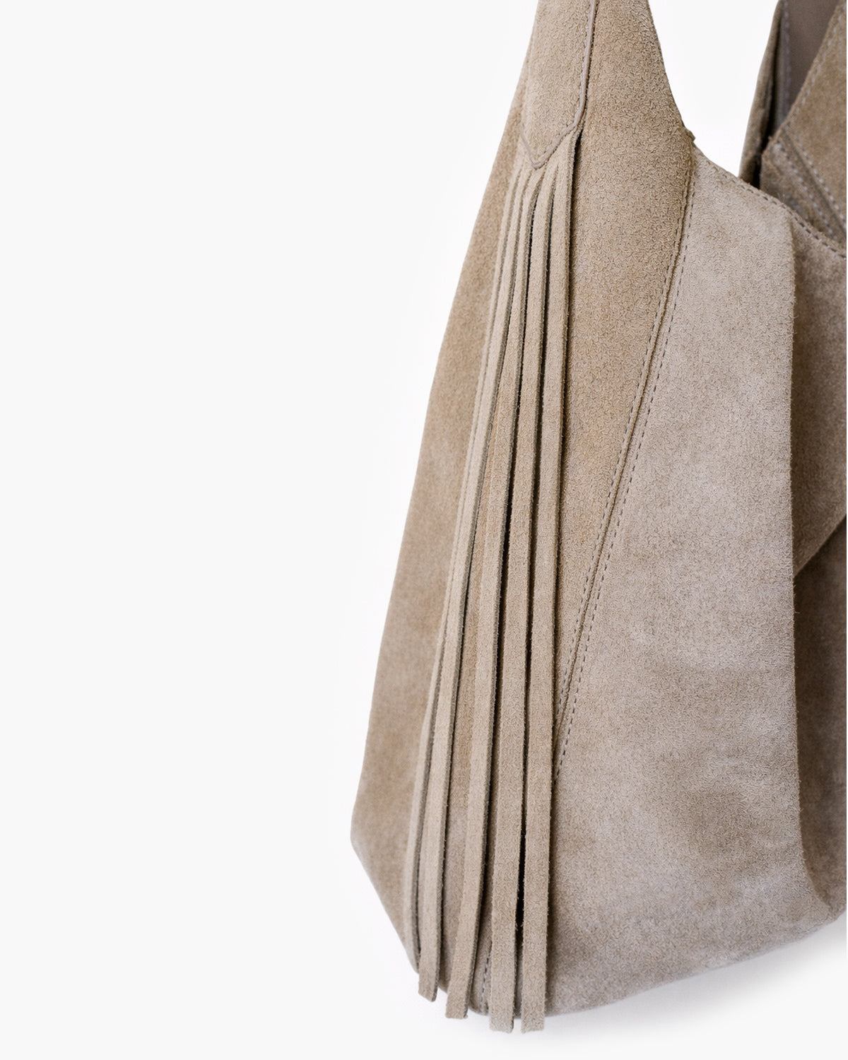 Close-up of a beige handbag with fringe design on a white background