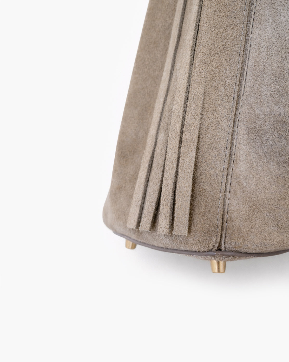 Close-up of a beige suede chair with fringe design on a white background