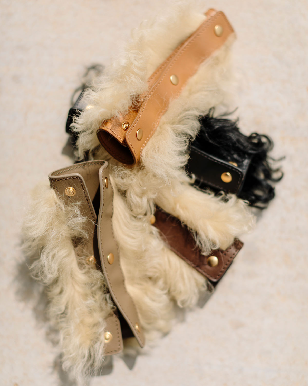 Close-up of a decorative item with fur and leather straps on a textured surface