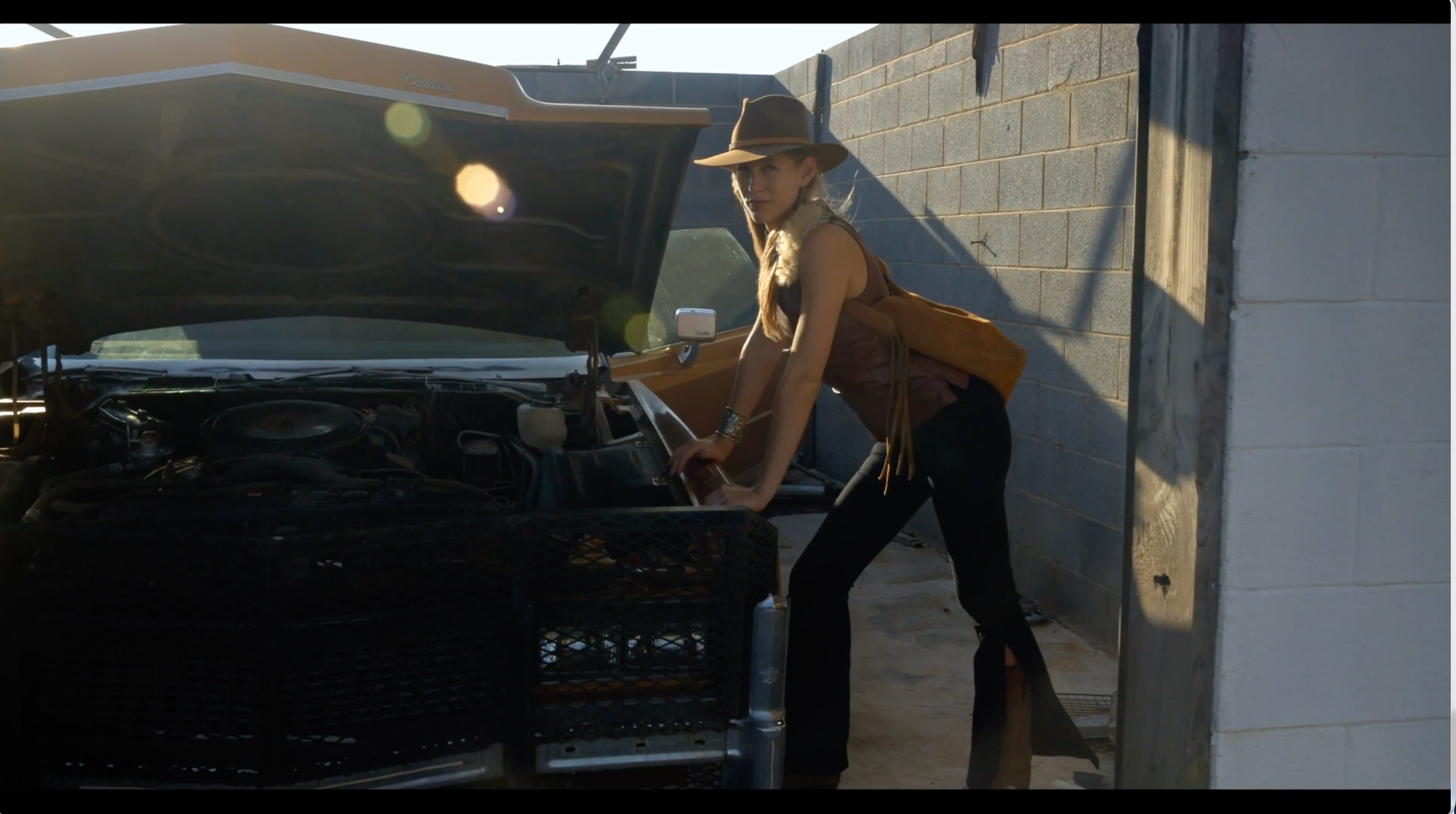 Load video: Video of two women in various locations on a ranch while carrying leather purses.